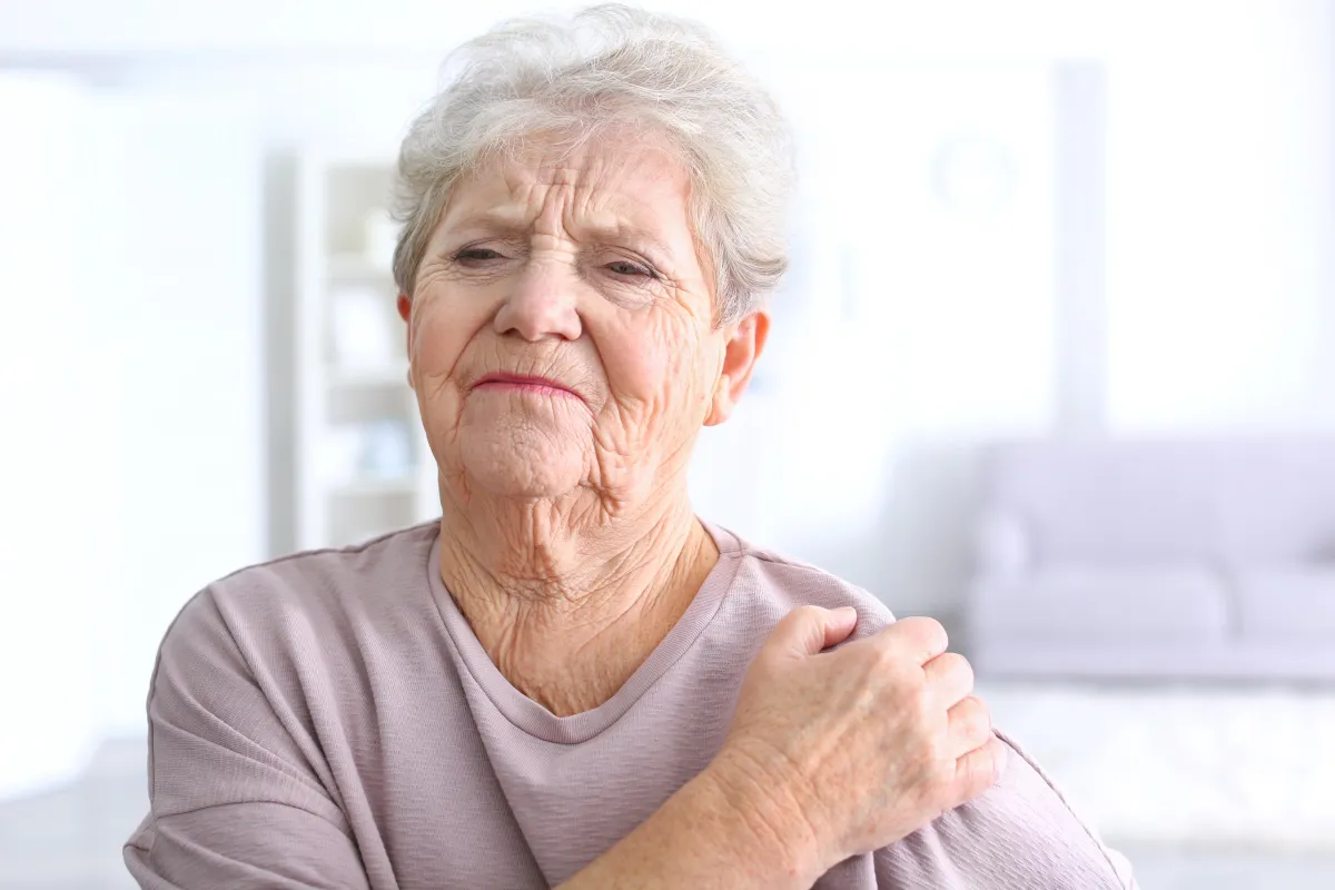 older women in pain holding her shoulder